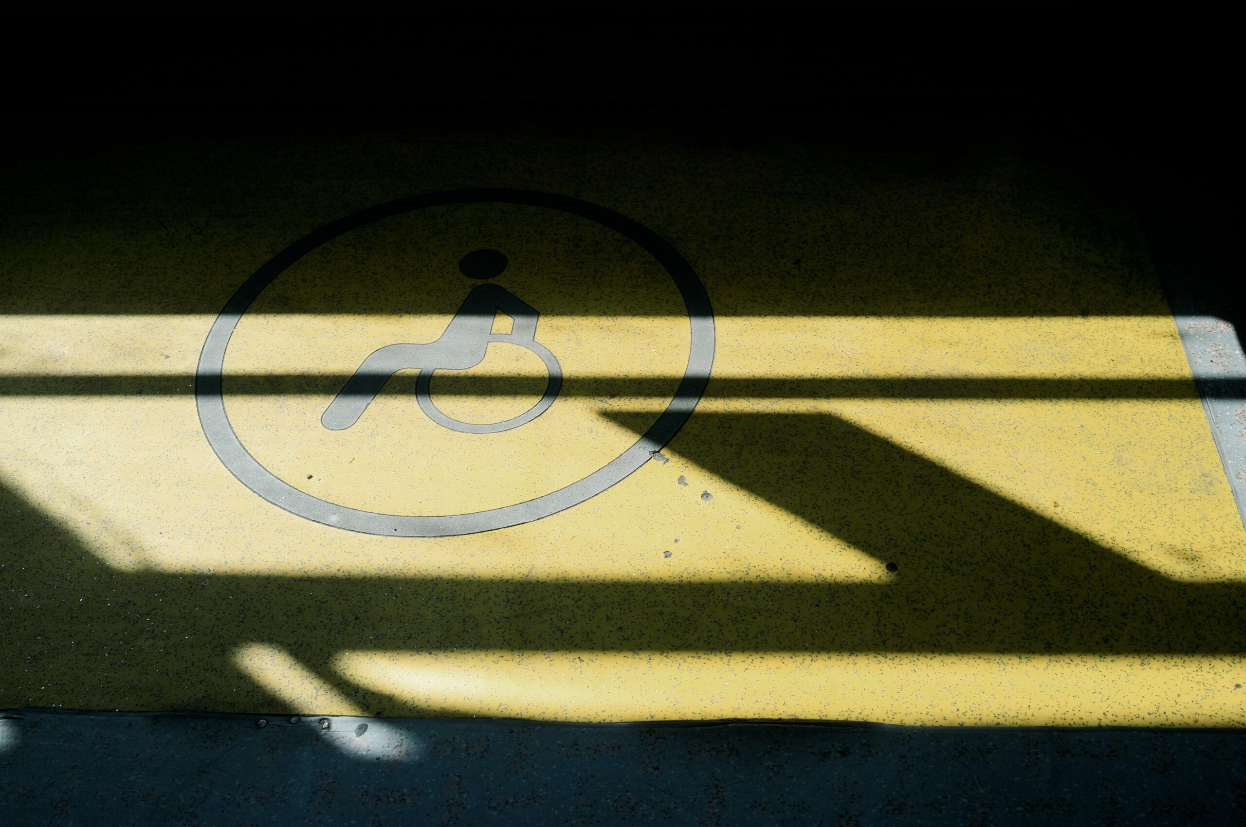 A photo of a yellow parking space marked with an image of a person in a wheelchair.